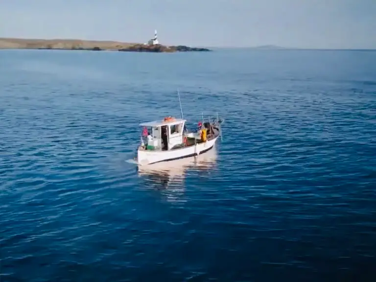 Barca de pesca artesanal Ets al-lots realizando pesca turismo en Menorca